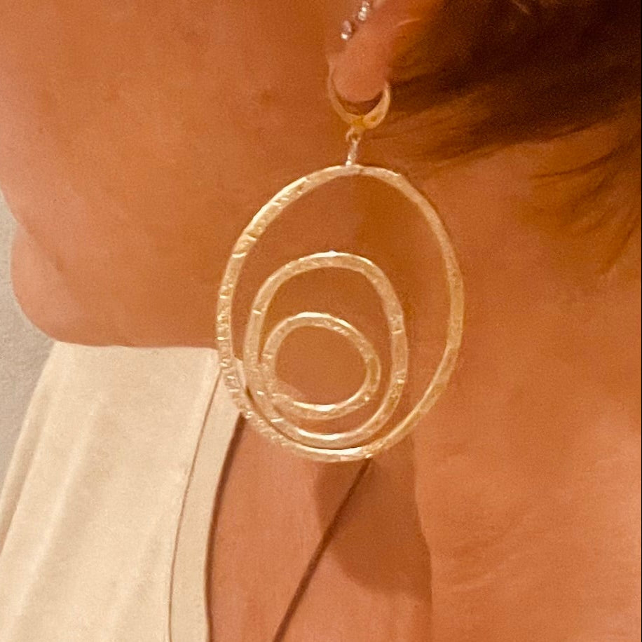 "Silenzi in orbita... Nelle orbite vuote, stelle di silenzio, tracce di un passato che sfugge e ritorna." - Linea 'Orbite': ciondolo, orecchini e anello in ottone martellato.