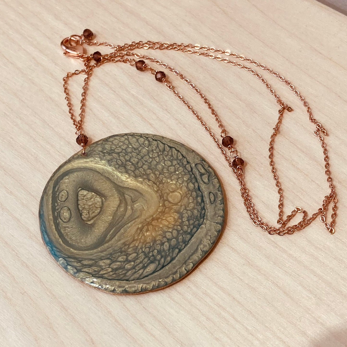 Collana in rame con ciondolo tondo, impreziosita con piccoli cristalli.
