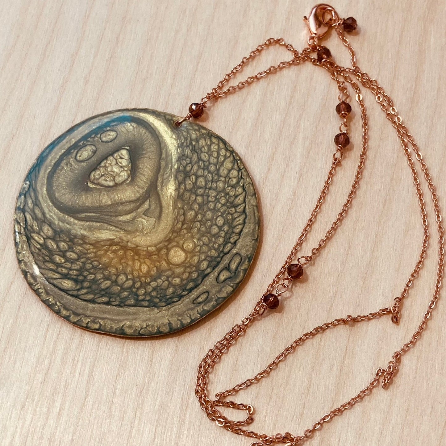 Collana in rame con ciondolo tondo, impreziosita con piccoli cristalli.