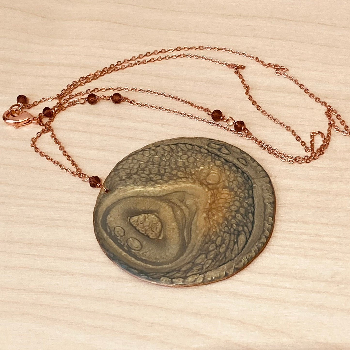 Collana in rame con ciondolo tondo, impreziosita con piccoli cristalli.