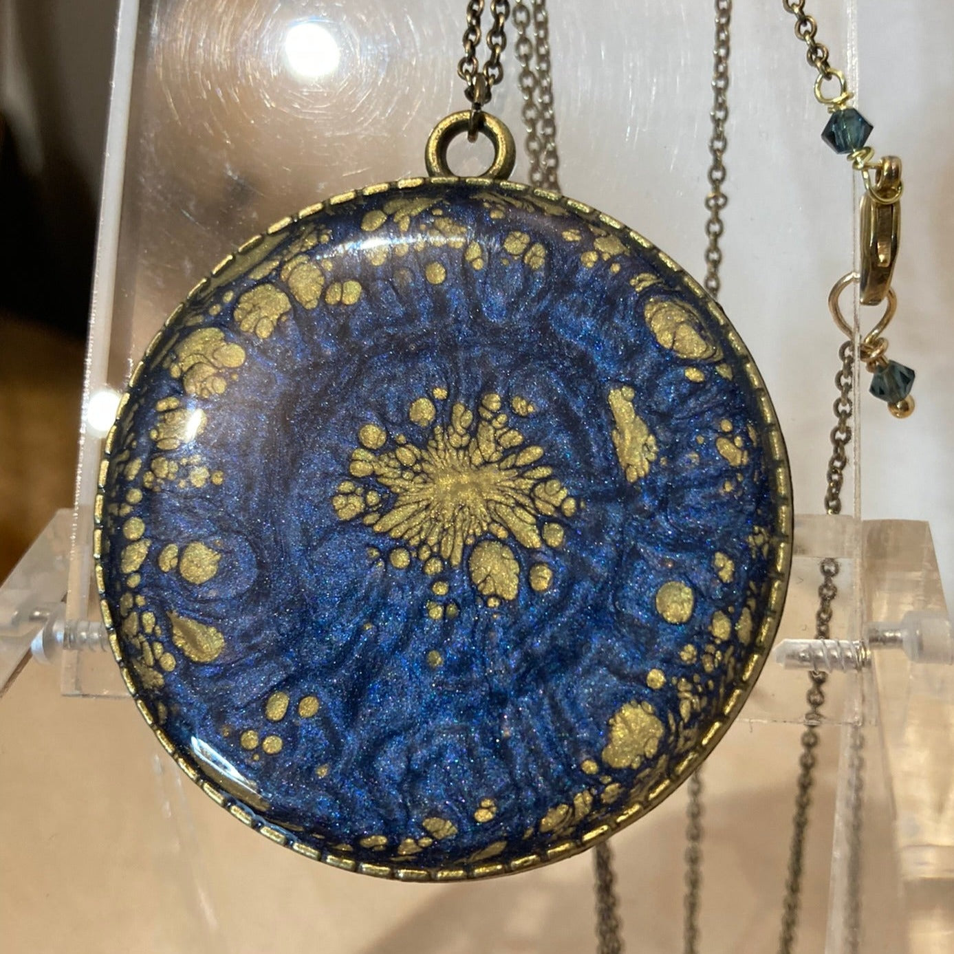 Collana in bronzo con ciondolo tondo dipinto e vetrificato a mano.