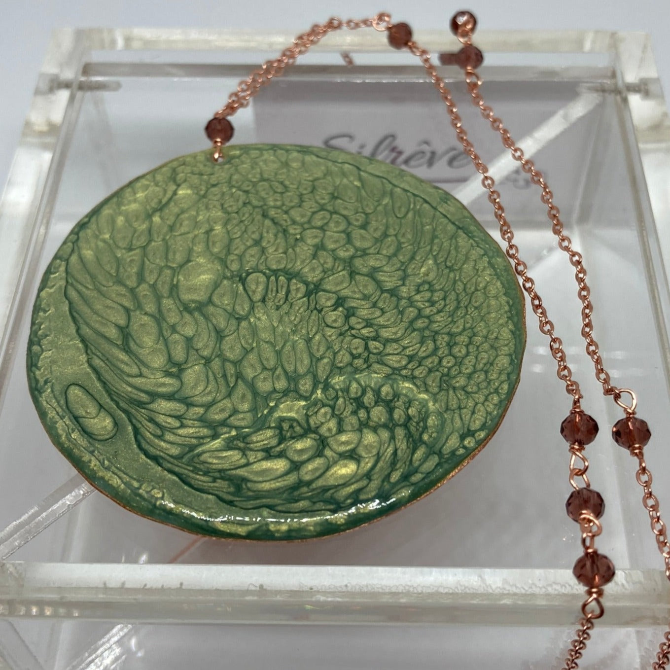 Collana in rame con ciondolo tondo, impreziosita con piccoli cristalli.