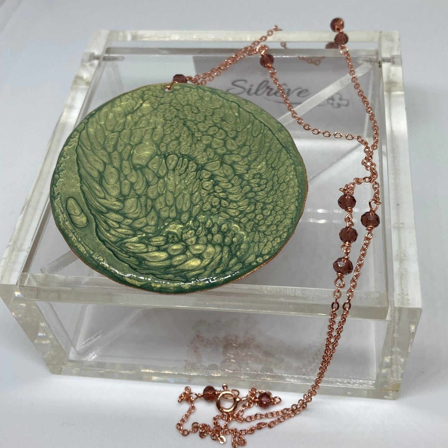 Collana in rame con ciondolo tondo, impreziosita con piccoli cristalli.