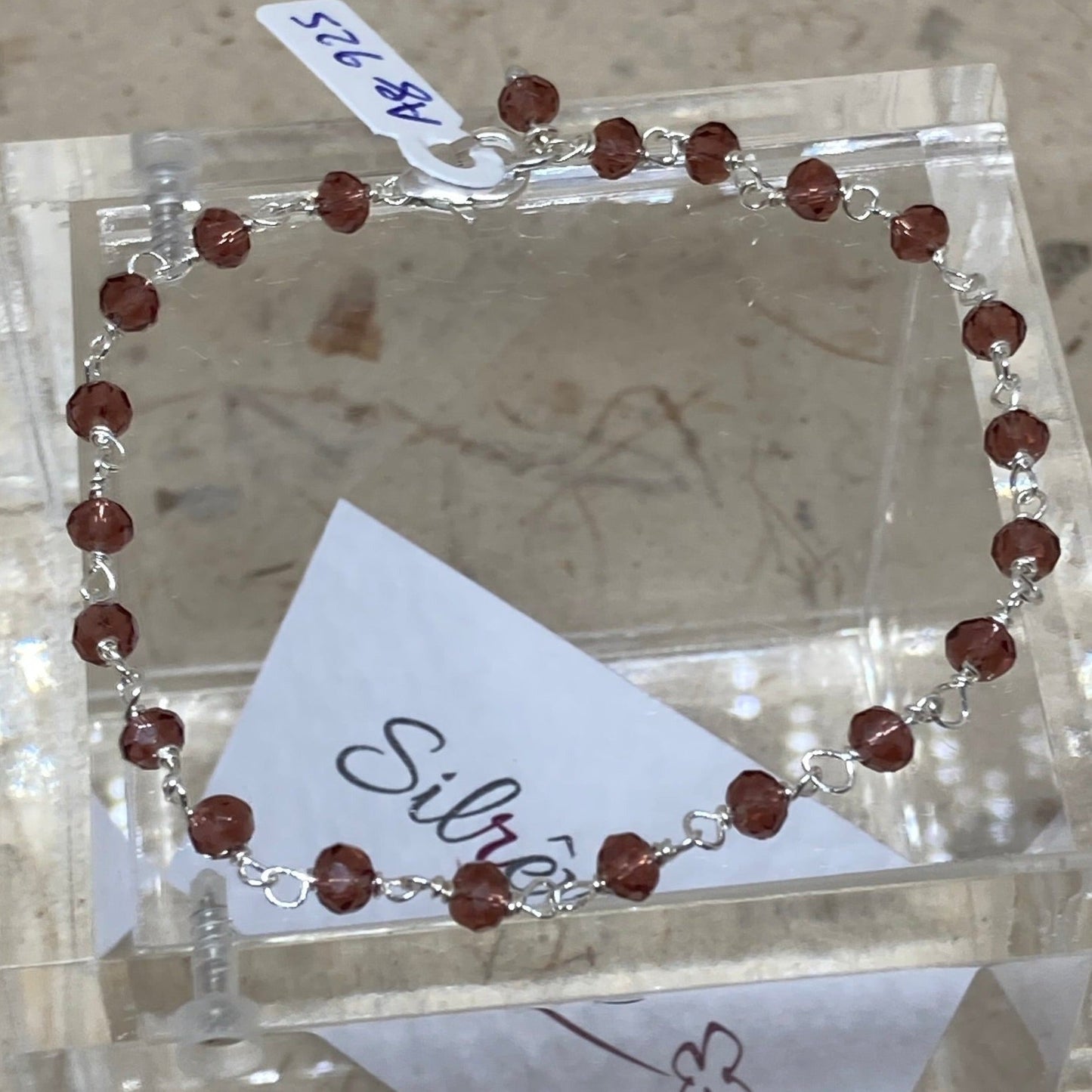 Braccialetto nodo orefice in Ag. 925, impreziosito con piccoli cristalli colorati.