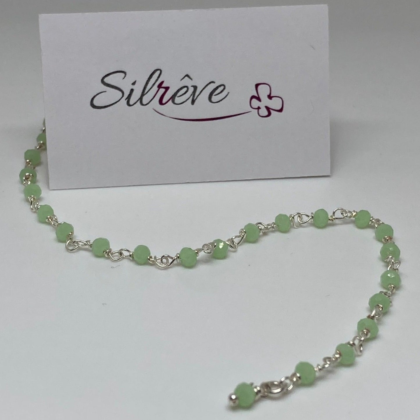 Braccialetto nodo orefice in Ag. 925, impreziosito con piccoli cristalli colorati.