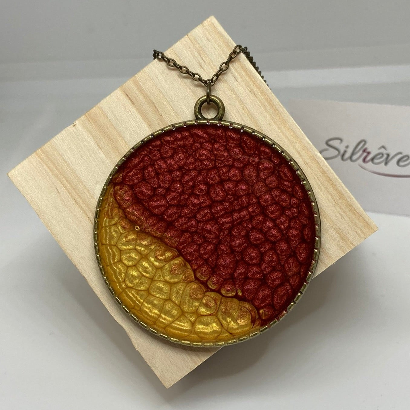 Collana in bronzo con ciondolo tondo dipinto e vetrificato a mano.