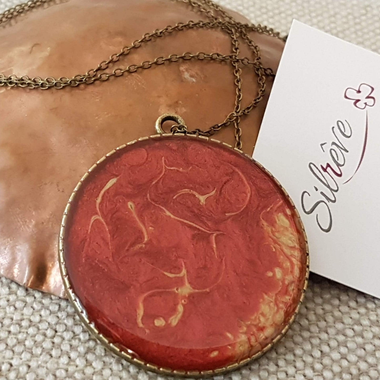 Collana in bronzo con ciondolo tondo dipinto e vetrificato a mano.