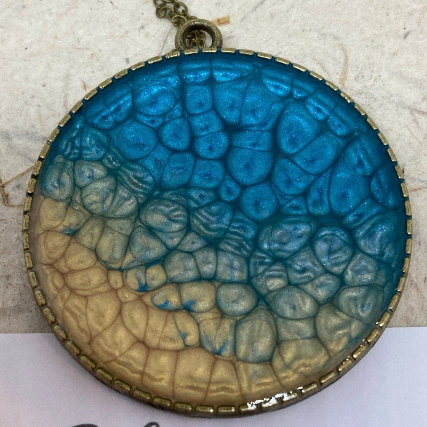 Collana in bronzo con ciondolo tondo dipinto e vetrificato a mano.