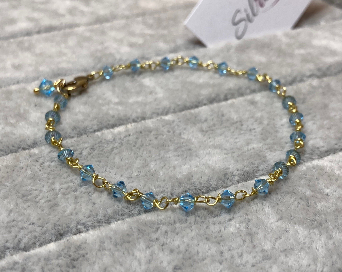 Braccialetto in ottone impreziosito con piccoli cristalli colorati.