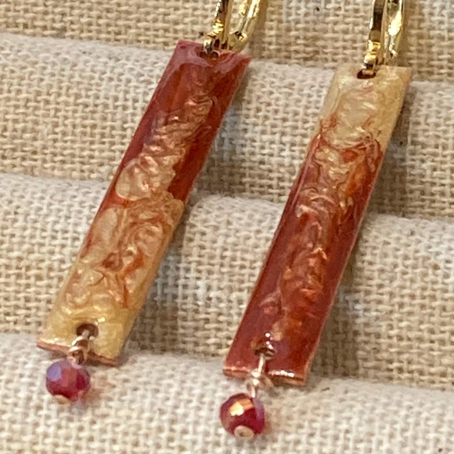 Orecchini rosso-oro in rame rettangolari, impreziositi con piccolo cristallo.